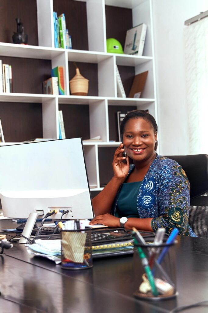 Professional African American woman smiling while working at her desk in an office.